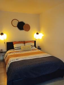 una camera da letto con un letto con due luci sul muro di Maison de village appartement RDC avec terrasse a Gy