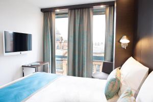 a hotel room with a bed and a large window at Motel One Manchester-Piccadilly in Manchester