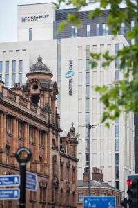 an old building in front of a tall building at Motel One Manchester-Piccadilly in Manchester