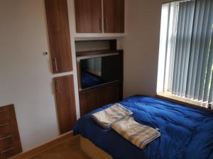 a bedroom with a blue bed and a television at The Happy House in Huddersfield