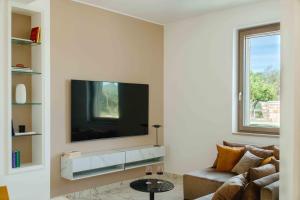 Una sala de estar con un televisor de pantalla plana en una pared. en ForiMia - Retreat, en Francavilla Fontana