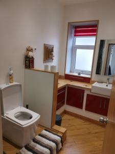 a bathroom with a toilet and a sink and a window at The Happy House in Huddersfield +18 photos