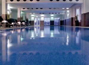a large swimming pool with blue tiles in a building at Macdonald Old England Hotel & Spa in Bowness-on-Windermere