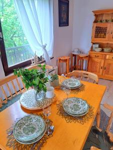 a wooden table with plates and wine glasses on it at Vikend Haloze-Zagorje in Jarki +24 photos