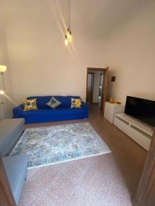 ein Wohnzimmer mit einem blauen Sofa und einem Flachbild-TV in der Unterkunft Le Petit Jardin Center Florence in Florenz