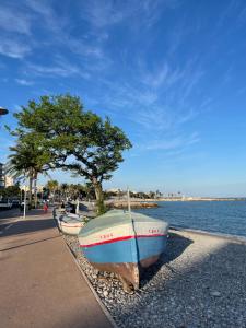 a boat sitting on the rocks next to the water at Cros de Cagnes, apartment with the Best Location in Cagnes-sur-Mer