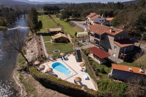 an aerial view of a house next to a river at Quinta do Rio Alva and Glamping Lodges in Mouronho