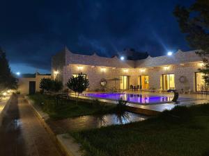 a house with a swimming pool at night at Villa Laarich in Essaouira