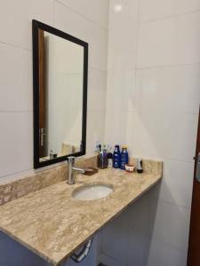 eine Badezimmerablage mit Waschbecken und Spiegel in der Unterkunft Chalé na serra da mantiqueira in Piranguçu + 30 Fotos