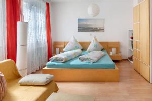 a bedroom with a bed with blue sheets and pillows at Ferienwohnung zur Schauinslandbahn in Horben