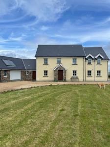 スウォンジーにあるPylewell Farm Rhossili, comfortable pet friendly couples getawayの庭に犬がいる大きな黄色い家