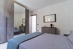 Un dormitorio con una cama grande y un espejo. en Casa Chiaraluna by BarbarHouse, en Porto Cesareo