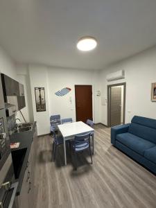 un soggiorno con un tavolo e un divano blu di Casa al mare a Finale Ligure