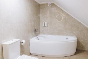 a bathroom with a white tub and a toilet at Eduard Hotel in Uzhhorod