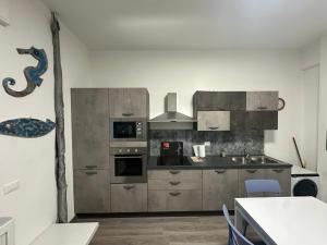 una cucina con elettrodomestici in acciaio inossidabile e un tavolo di Casa al mare a Finale Ligure