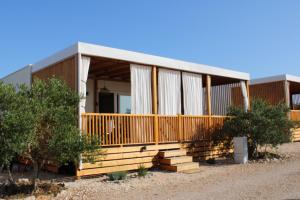 ドラゲにあるMobile home Maxの前に木々の入ったポーチのある家