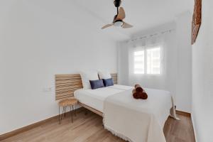 une chambre blanche avec un lit et une chaise dans l'établissement Apartament Palmside Torrevieja, à Torrevieja