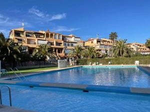 une grande piscine devant certains bâtiments dans l'établissement Apartament Palmside Torrevieja, à Torrevieja