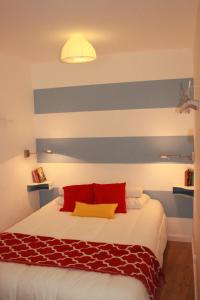 a bedroom with a bed with a blue and white striped wall at Casa Beco Do Castelo in Lisbon