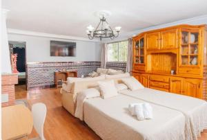 Un dormitorio con dos camas y una lámpara de araña. en Casita rural de invitados, en Alcalá de Guadaira 12 fotos más