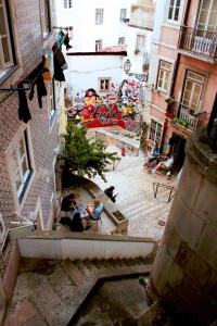 un grupo de personas sentadas en las escaleras de un edificio en Casa Beco Do Castelo, en Lisboa