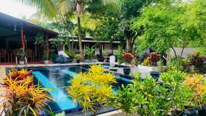 una piscina con piante di fronte a una casa di Hotel Samanala Sigiriya a Sigiriya
