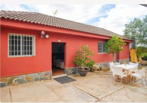una casa roja con mesa y sillas en Casita rural de invitados, en Alcalá de Guadaira