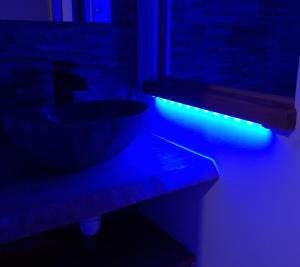 a bathroom with a sink with a blue light at Appartement Romantique Climatisé BELORIZON - 30 min de la mer in Pignans