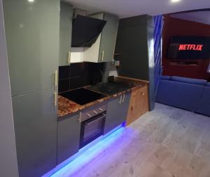 a kitchen with a stove top oven next to a couch at Appartement Romantique Climatisé BELORIZON - 30 min de la mer in Pignans