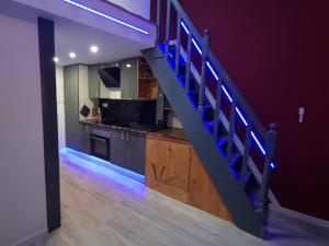 a kitchen with a staircase with blue led lights at Appartement Romantique Climatisé BELORIZON - 30 min de la mer in Pignans