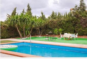 Una piscina con una mesa y sillas en un patio. en Casita rural de invitados, en Alcalá de Guadaira