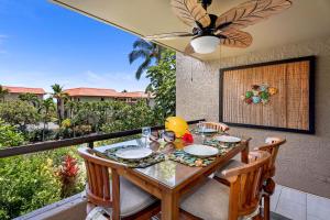 a table and chairs on a balcony with a view at Kona Pacific D524 Kauhale in Kailua-Kona