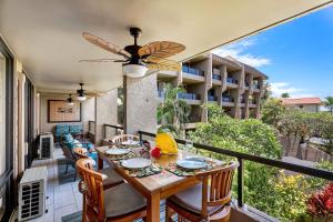 a balcony with a wooden table and chairs on a balcony at Kona Pacific D524 Kauhale in Kailua-Kona