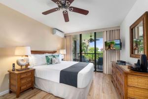 a bedroom with a bed and a ceiling fan at Kona Pacific D524 Kauhale in Kailua-Kona +32 photos