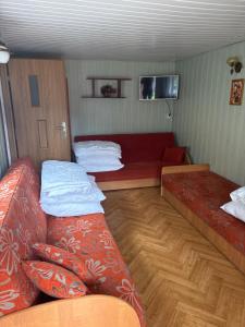 a small room with two beds and a couch at Domki u Dorotki in Jantar