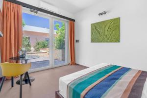 a bedroom with a bed and a table and a window at Sabhé Gallipoli in Gallipoli