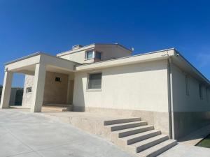 a large white house with a garage with stairs at Luxury villa Lara with private pool in Banjole