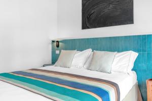 a bedroom with a bed with a striped blanket at Sabhé Gallipoli in Gallipoli