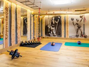 Ein Fitnessstudio mit Yogamatten und Hanteln auf einem Holzboden in der Unterkunft Hotel Alte Post Fieberbrunn in Fieberbrunn