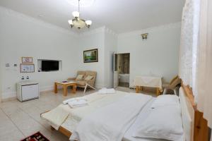 a bedroom with a large bed and a living room at Hotel Familja in Ura Vajgurore