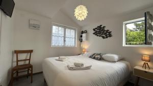 a bedroom with a bed with towels on it at Les Alouettes, maison avec studio pour 4 personnes proche de la baie. in Le Crotoy