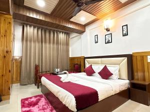 西姆拉Hotel Avalanche的卧室里有一张大床，上面铺着红毯子