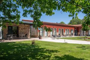 A RúaAlojamientos rurales O Acivro的院子内带桌椅的砖砌建筑