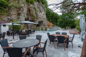 a patio with tables and chairs and a pool at Pensiunea Apuseni Wild in Remeţi