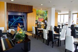 a restaurant with tables and chairs and a piano at Hotel Eurosol Leiria & Jardim in Leiria