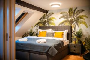 ein Schlafzimmer mit einem Bett mit gelben Kissen und Palmen in der Unterkunft A/C LUX Rooftop APT 6BR+3.5Bath Wenceslas square in Prag