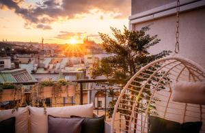 einen Balkon mit Blick auf eine Stadt bei Sonnenuntergang in der Unterkunft A/C LUX Rooftop APT 6BR+3.5Bath Wenceslas square in Prag
