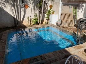 a pool with blue water in a backyard at Habitacion en Casa Huelves in Huelves