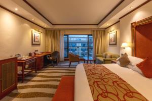 ein Hotelzimmer mit einem Bett und einem Schreibtisch in der Unterkunft Kigali Serena Hotel in Kigali