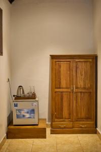 a kitchen with a microwave and a wooden cabinet at Abangan Bungalow in Ubud